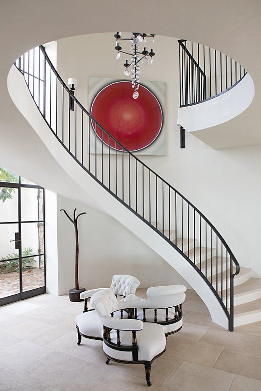 The entry’s dramatic curved staircase “was a big love of the lead architect, Drex Patterson,” Chris says. “We could have filled up the space, but it didn’t seem to call for it. It was a happy accident.” The dynamic painting is by Robert Schaberl. 

 

 
